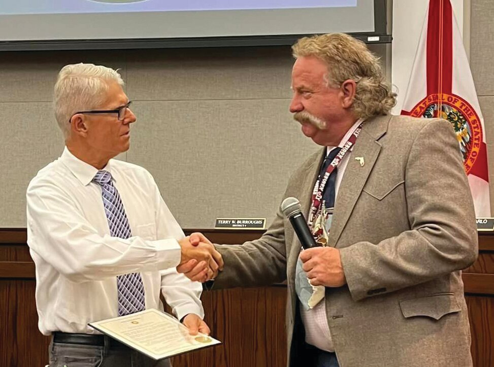 OKEECHOBEE -- Okeechobee County Commissioner Brad Goodbread (right) presented the Domestic Violence Awareness Month proclamation to Jonathan Bean (left) of Martha's House on Sept. 28.